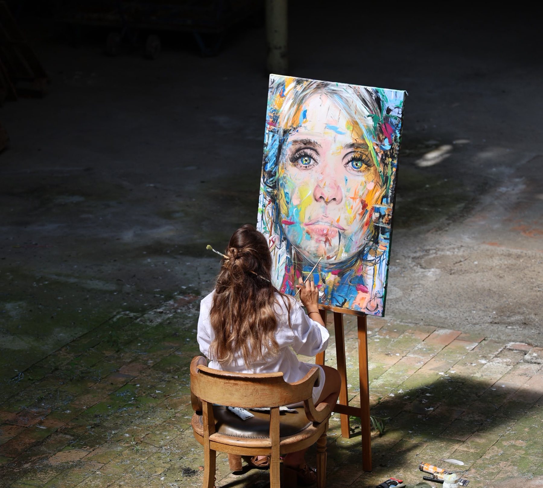 Justine Lepoutère à l'atelier, face à une toile en cours